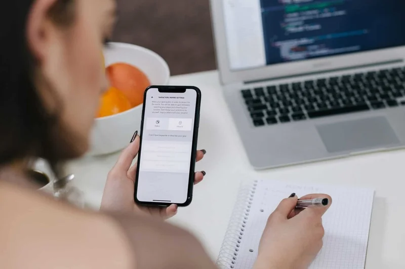 women holding space gray iphone x and black pen