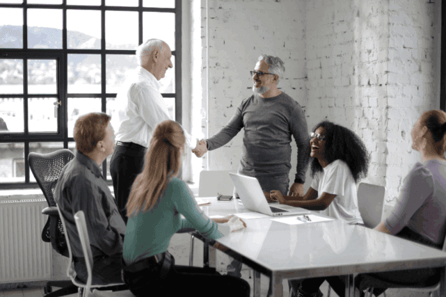 A photo of 2 people shaking hands in a modern workspace