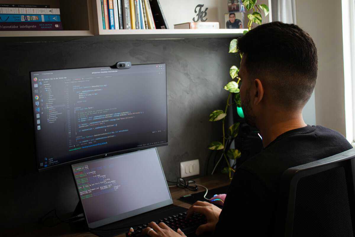  Ai Developer working on code at a dual-screen setup in a home office. testimonial