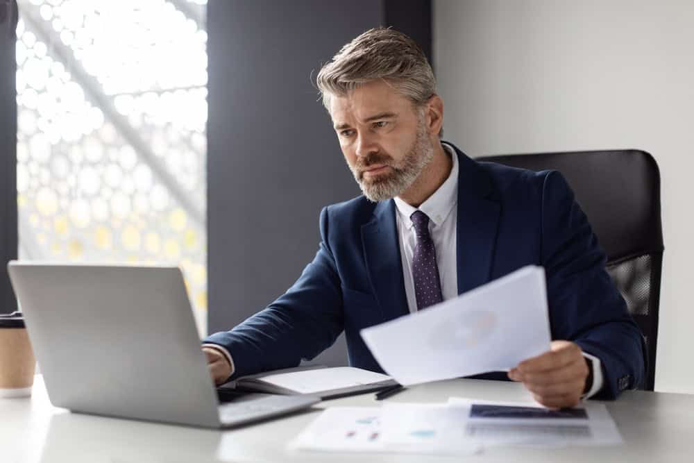 Businessman working with laptop and documents In office testimonial