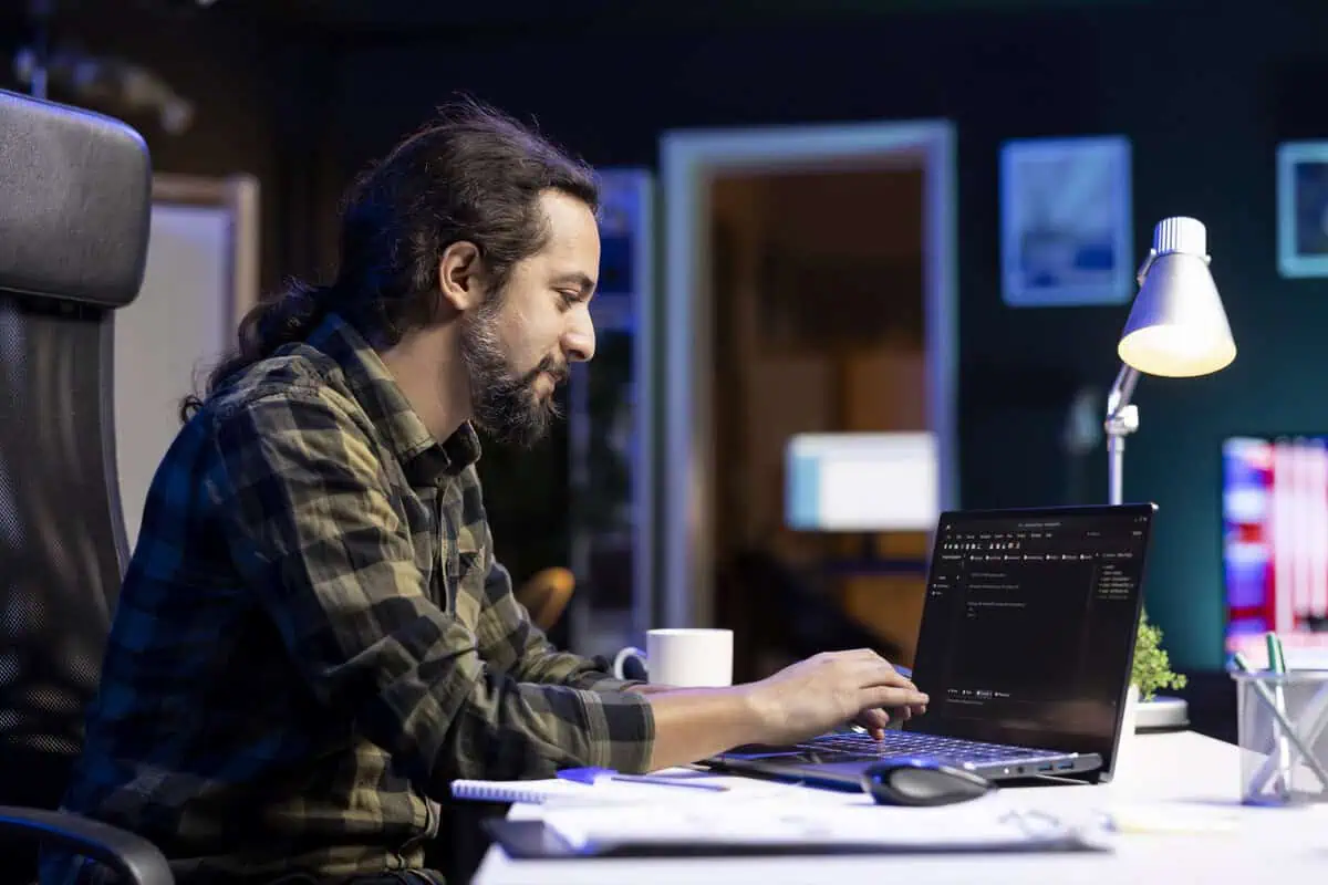 Programista .Net pracujący przy laptopie w nowoczesnym biurze.