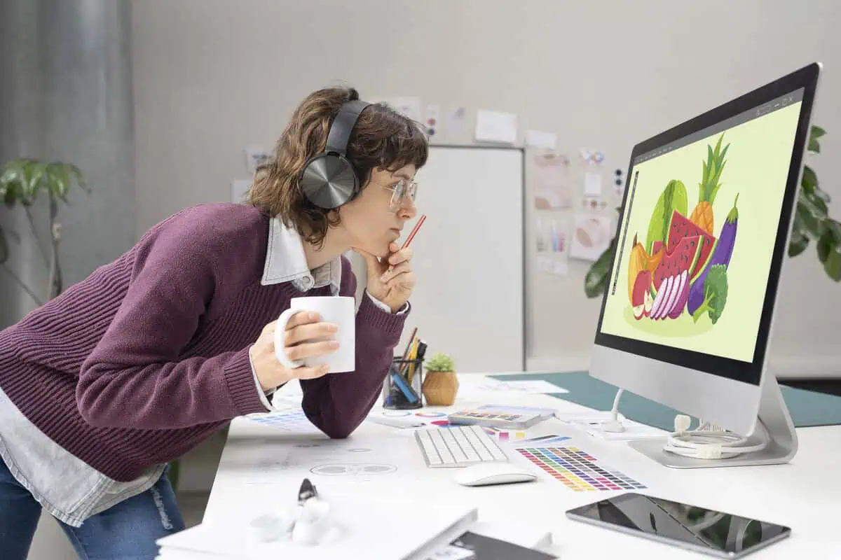 CA designer looking at a computer screen displaying fruits.